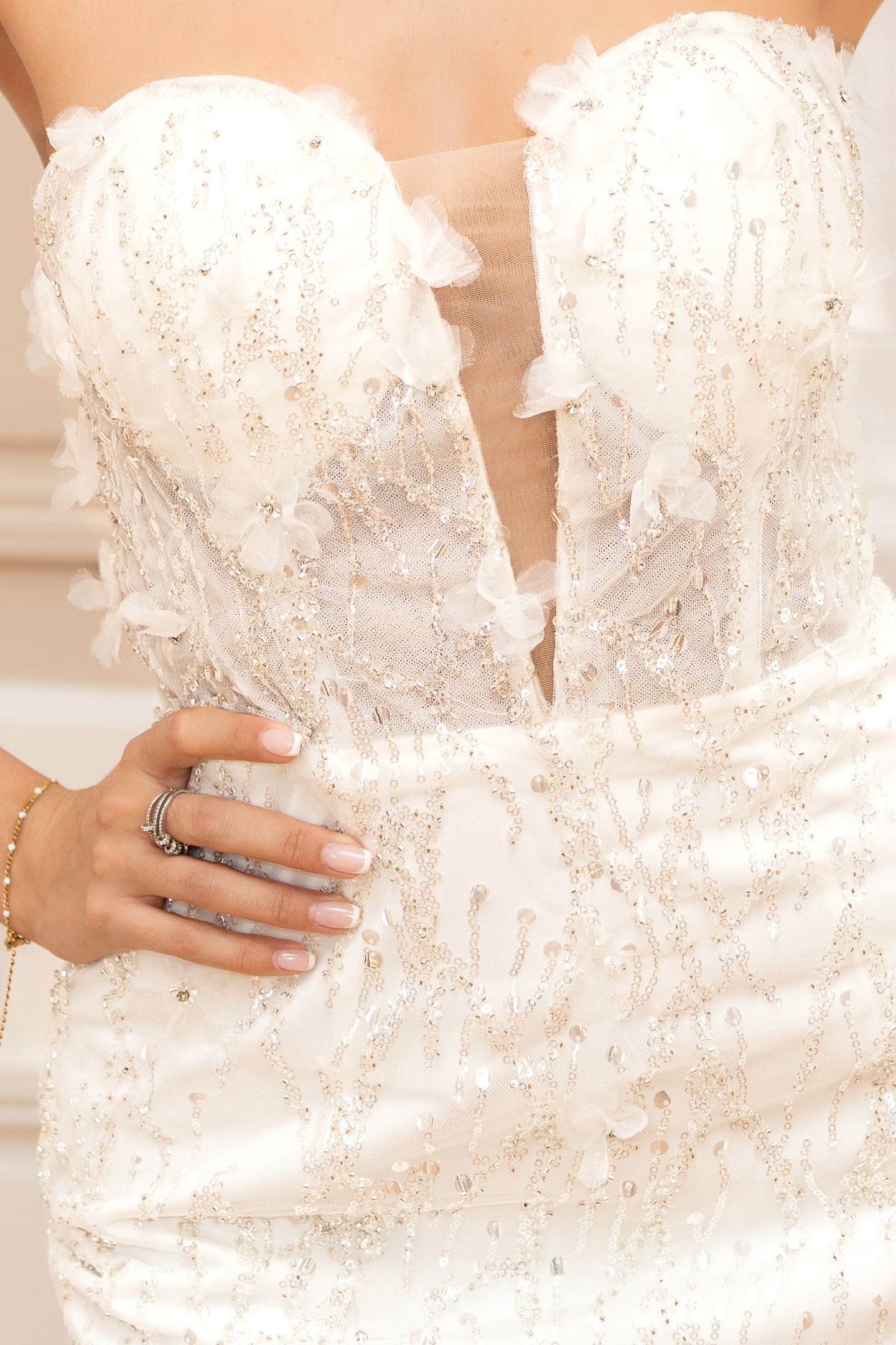 Main posée sur un bustier brodé lors d'un essayage