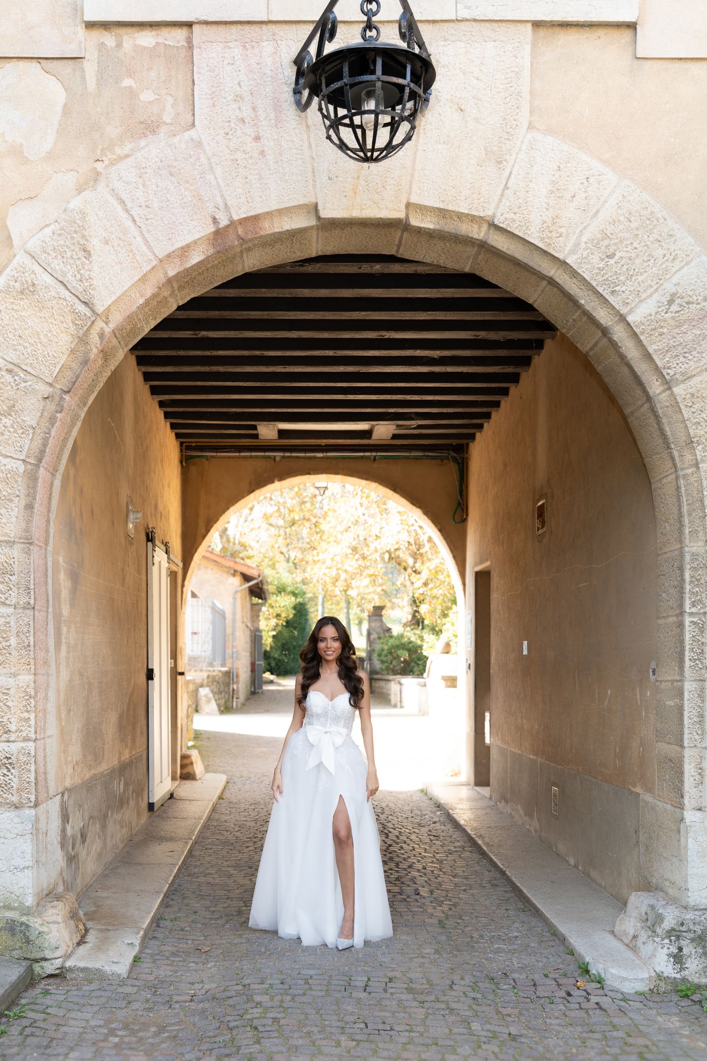Mariée de dos en robe à volants devant des portes élégantes