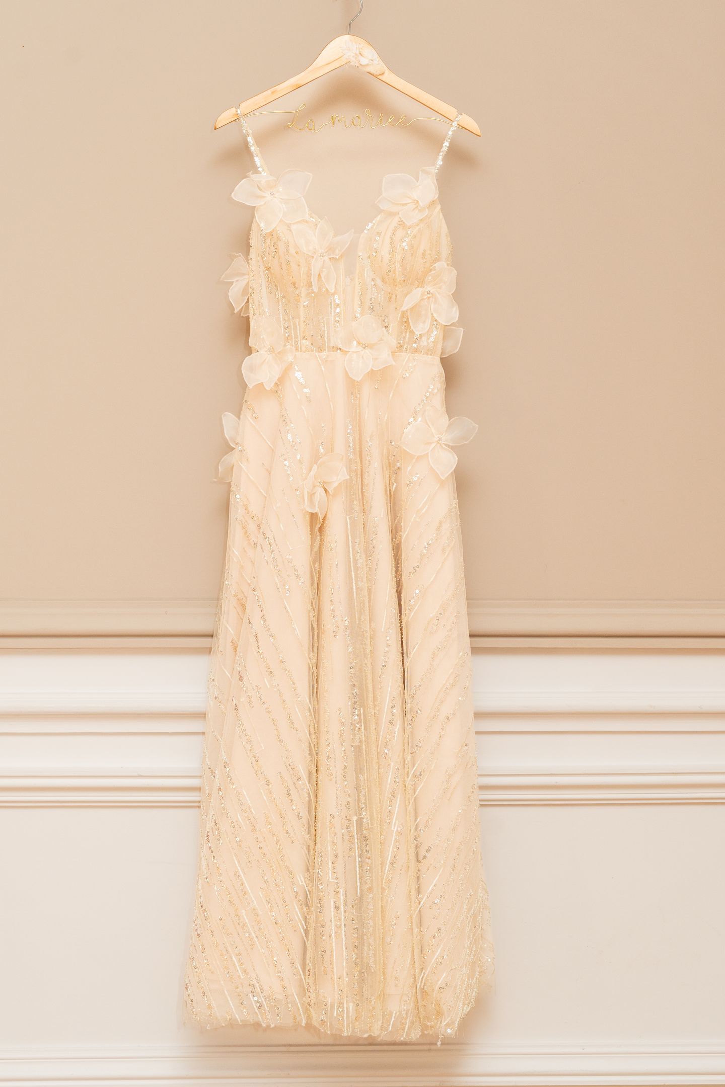 Robe de mariée florale dorée suspendue dans l'atelier