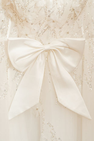 Mariée en robe brodée sur terrasse avec vue sur l'eau